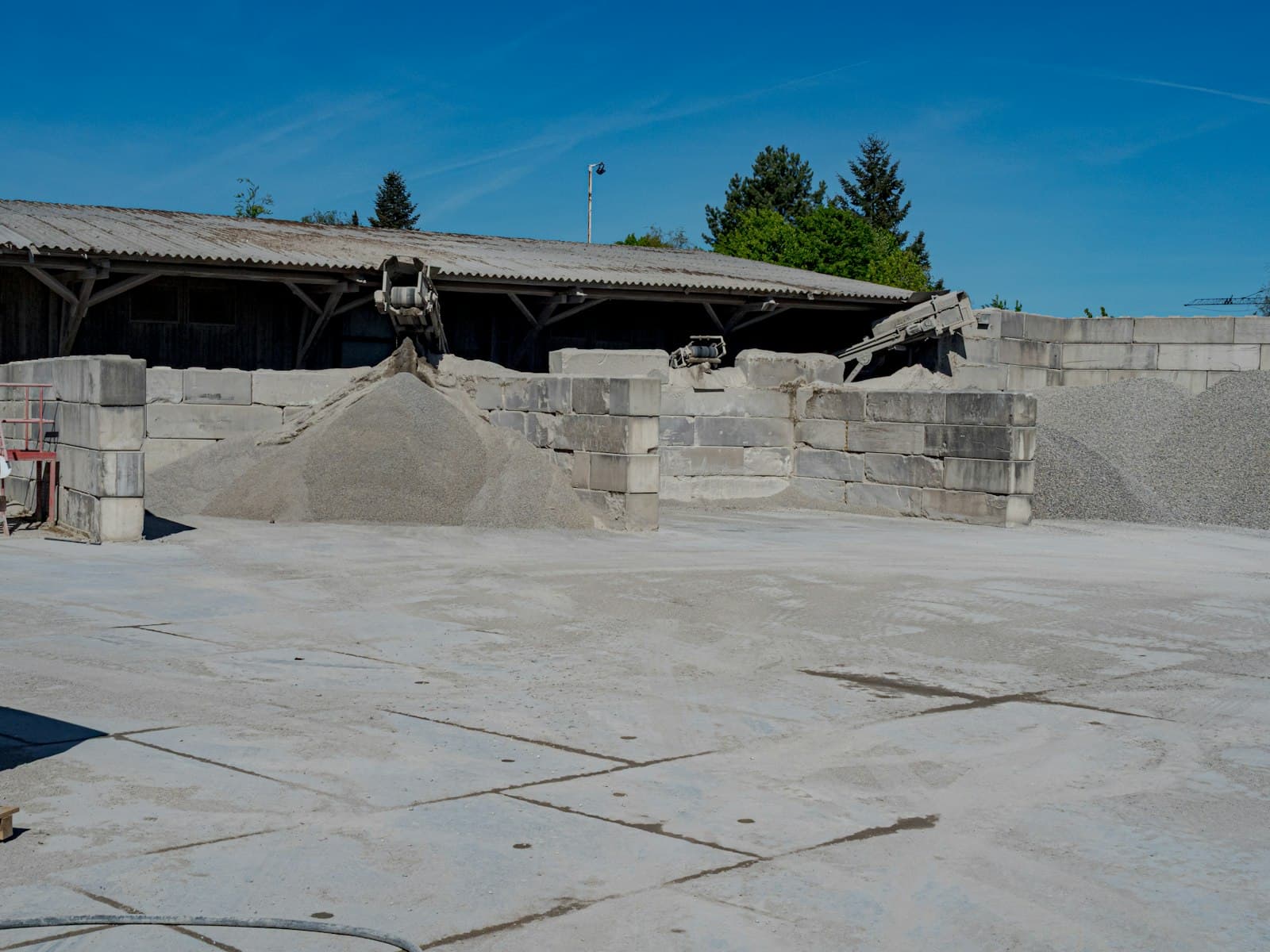 Graded fine and coarse aggregate stockpiles in producer storage bays with conveyors